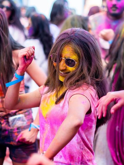 A guest dancing at our Holi Utsav, covered in pink and yellow powder. The joy and freedom of the festival are what I aim to capture and facilitate.