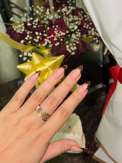 A simple yet stunning take on animal print. These almond-shaped nails feature a classic French tip with a hand-painted leopard print design.