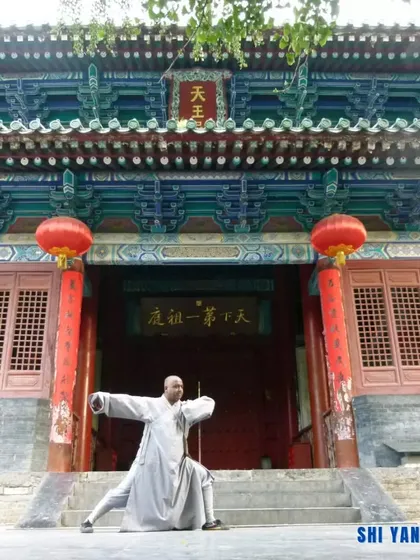 Performing a low stance from a traditional form at a temple in China. These stances build leg strength, stability, and a low center of gravity, which are crucial for generating power.