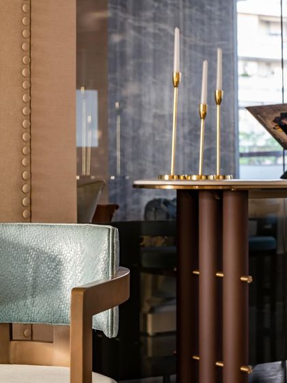A detail shot of the console table, highlighting the sculptural base and the elegant brass candle holders. These small elements contribute to the overall feeling of refined, thoughtful design.