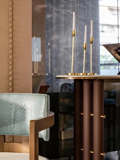A detail shot of the console table, highlighting the sculptural base and the elegant brass candle holders. These small elements contribute to the overall feeling of refined, thoughtful design.