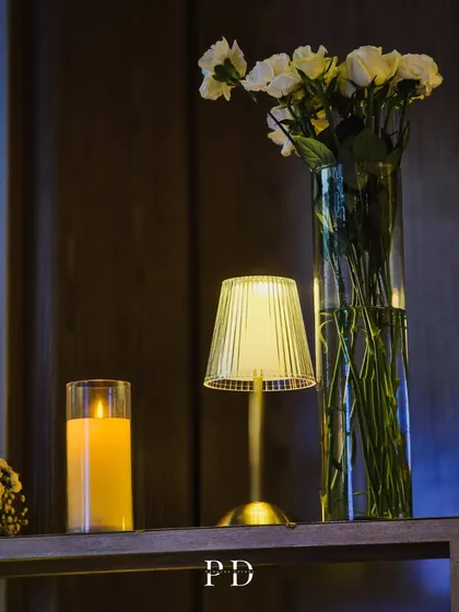 A stylish decor detail for a modern Sangeet, using clean lines, simple florals, and warm ambient lighting to create a sophisticated look.