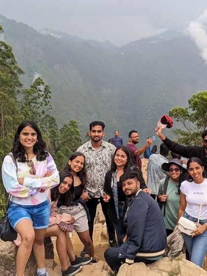 A happy group photo from a viewpoint overlooking the misty hills.