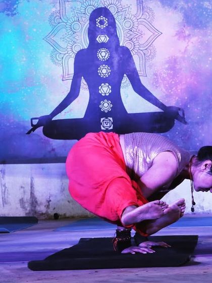 "Yoga is 99% practice & 1% theory." Holding Bakasana during a performance, with the chakra silhouette in the background reminding us of the energetic aspect of our practice.