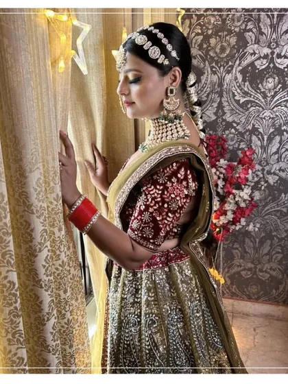 A side profile of a bride in a traditional lehenga, showing the beautiful hair and makeup that completes the look.
