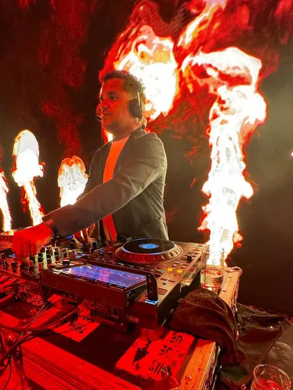 A side view of me at the console during the fire-themed after-party. I'm focused on the mix, ensuring a seamless flow of music.