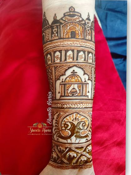 A close-up of the arm, this design showcases a beautifully rendered doli scene, surrounded by intricate patterns and peacock figures.