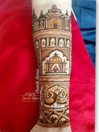 A close-up of the arm, this design showcases a beautifully rendered doli scene, surrounded by intricate patterns and peacock figures.
