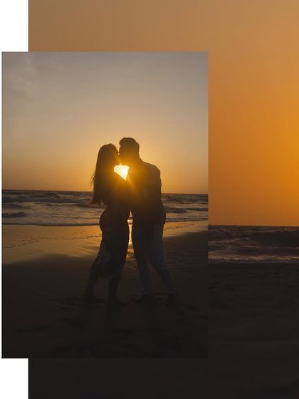 A romantic silhouette of a kiss at sunset. The sun flares perfectly between them, creating a magical and iconic pre-wedding photograph.