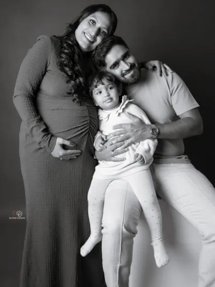 A classic family portrait in black and white. This pose beautifully captures the family of three, soon to be four, in a moment of togetherness.
