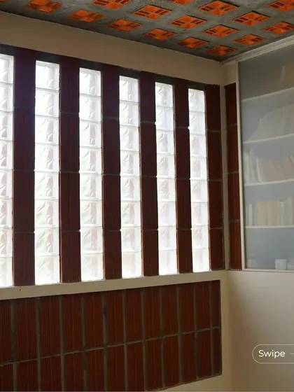 A study or library space in the Manjunath Residence, featuring walls of glass blocks and terracotta that allow for diffused natural light, perfect for reading.