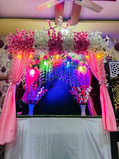 This beautiful makhar setup features a theme of pink and white artificial cherry blossoms. The addition of pink drapes and colorful fairy lights creates a bright and cheerful atmosphere for the Ganpati festival.