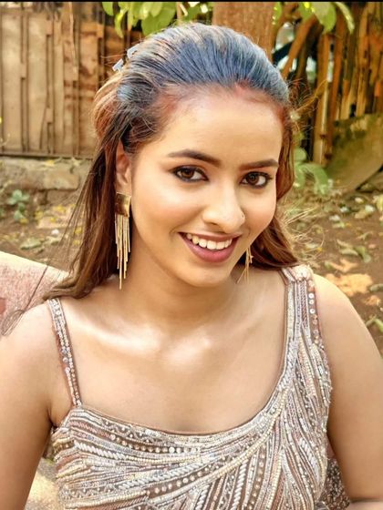 A happy close-up of a model in a sparkling beige gown.