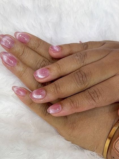 A simple yet beautiful set of short almond nails with a shimmering pink cat-eye gel polish.