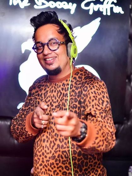 Pointing at the camera from behind the decks. This is an invitation to join the party and let the music take over.