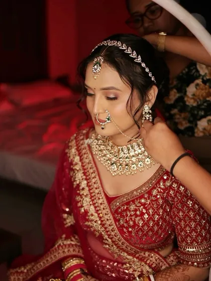 Final touches on a beautiful bride in her red lehenga. It's these moments of preparation that are so special.