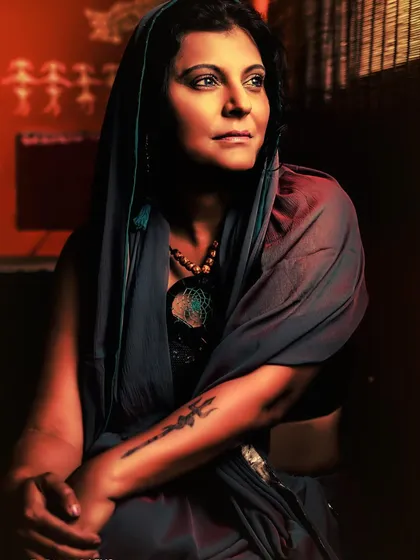 This portrait uses warm, dramatic tones to create a powerful, painterly feel. The subject, draped in a scarf, looks away with a strong, thoughtful expression, her inner world illuminated by the rich light.