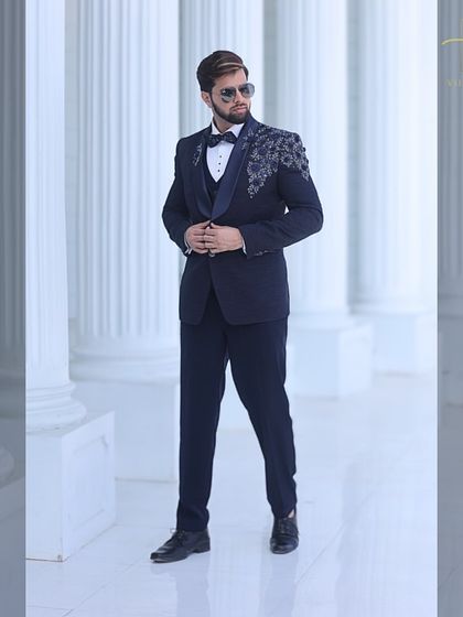 A full shot of the navy tuxedo, showing how the embroidery adds a touch of glamour.