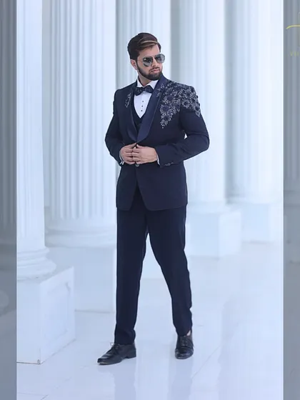 Our model showcases the confident fit of a custom-made navy tuxedo. The structure of the jacket and the precise tailoring are designed to flatter your frame.