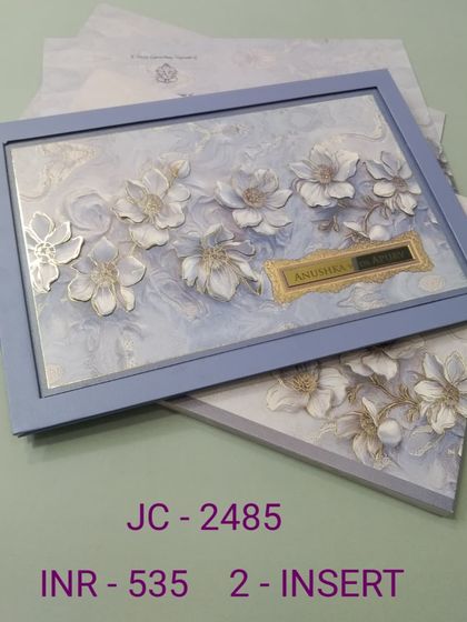 This invitation features 3D white and silver flowers against a marbled blue background, all set within a matching frame. It's a modern and artistic choice for a sophisticated event.