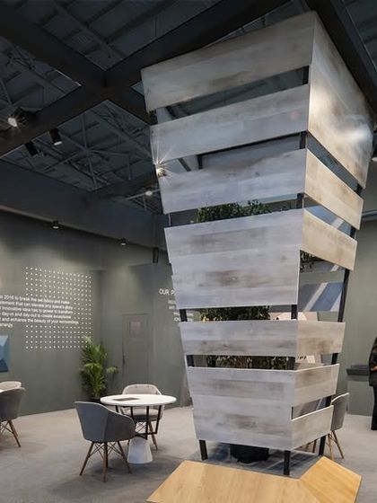 An interior view of the Makers stall, showing how the central sculpture anchors the space. The surrounding walls are used for product information and sample displays, with dedicated tables for client meetings.