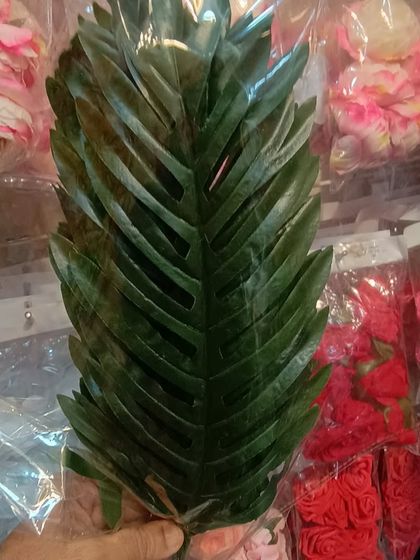 A realistic artificial palm leaf. These are great for creating a tropical or jungle-themed decoration for parties or festivals.