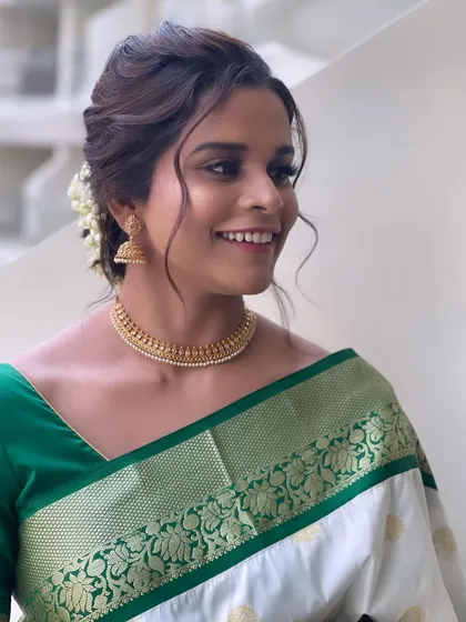 The happy sister of the groom, her hair beautifully styled to complement her silk saree.