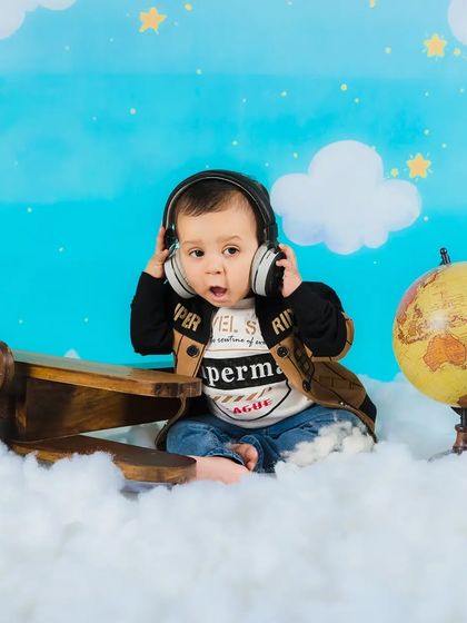 Listening to some tunes while flying high! A baby boy wears headphones in this fun and creative aviator-themed shoot.