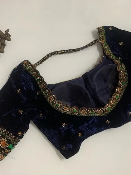 I love working with velvet for its rich texture. This navy blue velvet blouse features multi-colored threadwork and zardozi embroidery, perfect for a winter wedding.