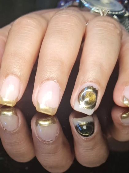 A side view of the gold chrome French manicure with a unique 3D embellishment.