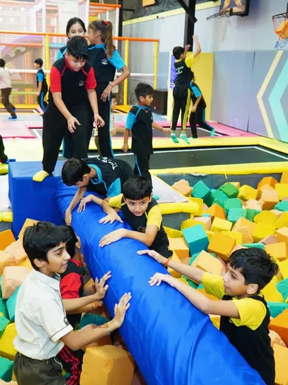 Teamwork makes the dream work. Kids work together to move a soft play log in the foam pit.