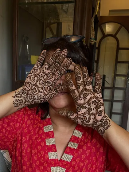 A playful pose from a happy client, showing off her fully covered palms with a dense floral pattern.