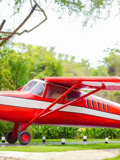 A unique and adventurous maternity shot with a vintage red airplane as the backdrop.