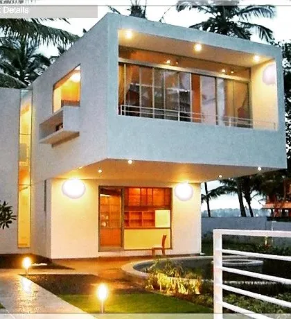 A contemporary villa designed for a compact plot in Bangalore. The structure uses a clean, minimalist aesthetic with strategic lighting that gives the home a warm, inviting glow after sunset, proving that modern design can also feel like a sanctuary.