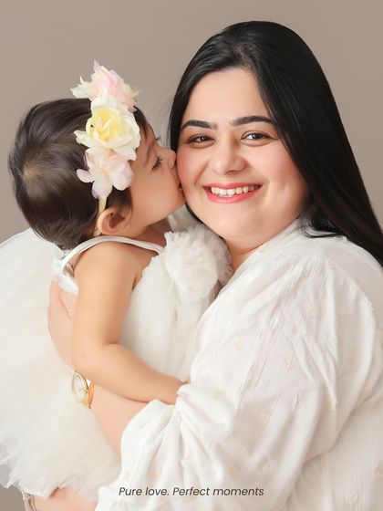 A sweet kiss for mom. These are the candid, loving moments that make for the most cherished family photographs.