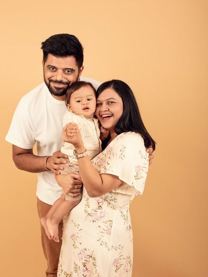 Capturing the joy and excitement of new parents. This studio family portrait is full of laughter and love, a perfect memory of this special time.