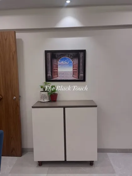 A simple yet elegant shoe cabinet placed near the entrance. This functional piece provides necessary storage while complementing the overall aesthetic of the home.