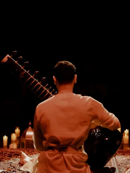A view from behind me as I face the candle-lit stage. This is my perspective just before I begin to play, grounding myself in the space we are about to create.