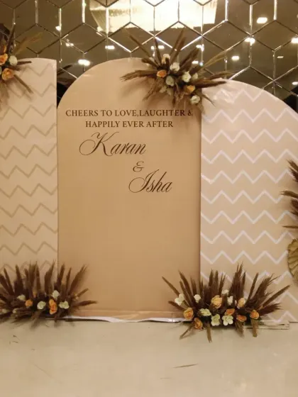 This is a modern, boho-chic engagement backdrop I created. It features custom-cut panels with the couple's names, "Karan & Isha," accented with pampas grass and dried floral bouquets.