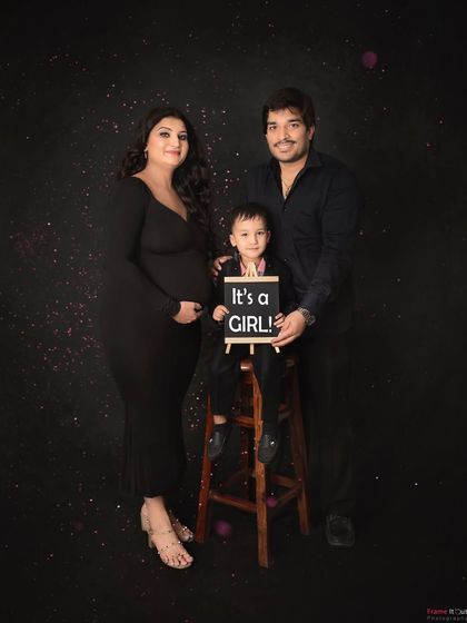 A classic and elegant family portrait to announce their baby girl. The simple black outfits and starry background create a timeless look for this special moment.