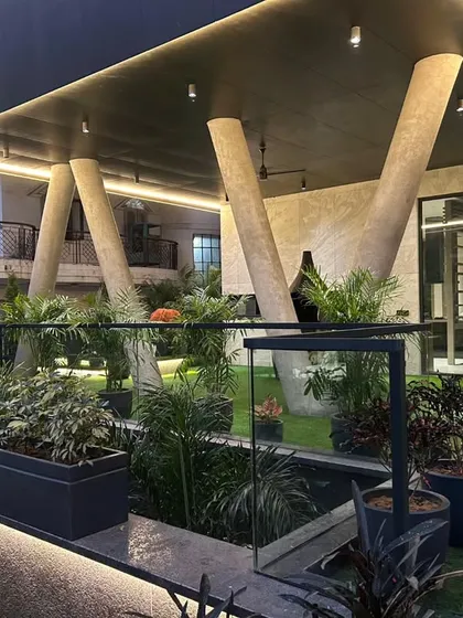 A modern outdoor structure with a covered porch supported by striking slanted pillars, creating a dramatic architectural statement on this rooftop.