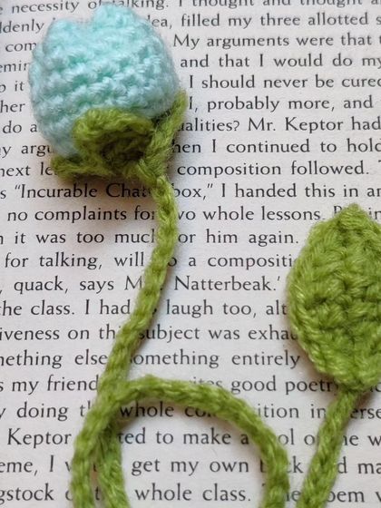 A light green tulip bookmark inside a book.