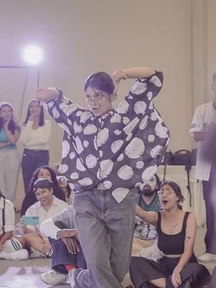 A dancer showcases her unique style in the 2v2 Open Style battle. The open style category allows for incredible creativity and fusion of different dance forms.