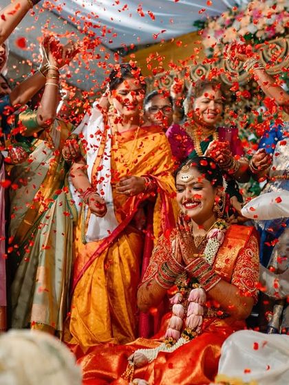 A wide shot of a couple being showered with rose petals by their family and friends. A moment of pure celebration and happiness.