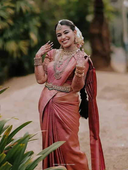 A joyful portrait of the bride, her hands adorned with henna, her smile bright and happy.