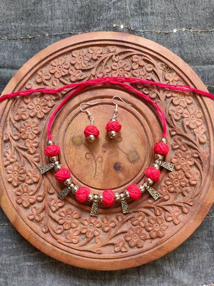 This thread bead necklace is available in a variety of colors like orange, green, yellow, blue, and red. It's a simple yet elegant accessory, perfect for adding a pop of color to your festive wear.