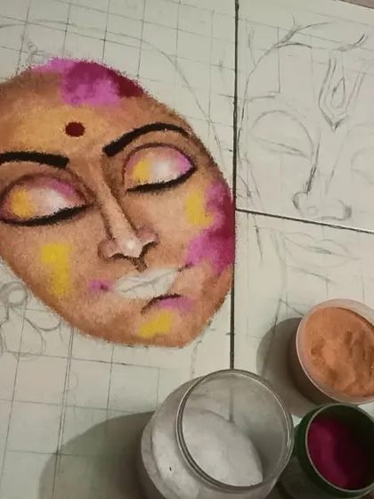 This image shows the initial stages of creating a portrait rangoli. I start by sketching the face and then begin layering the base skin tones before adding details and shading.