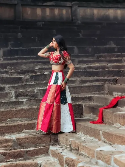 A wide shot that showcases the grandeur of the location and the beauty of the traditional outfit. The composition is dramatic and cinematic.