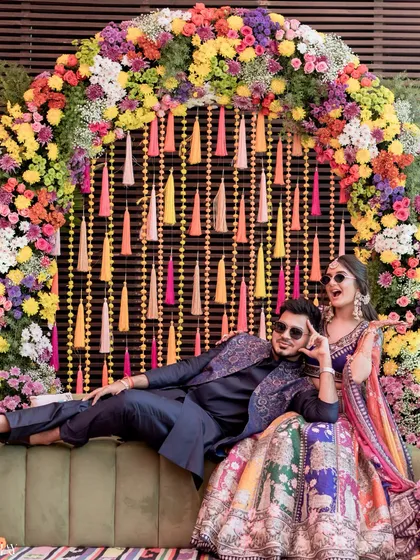 A fun and dramatic pose from the couple at their colorful Mehendi carnival, showcasing their playful personalities.