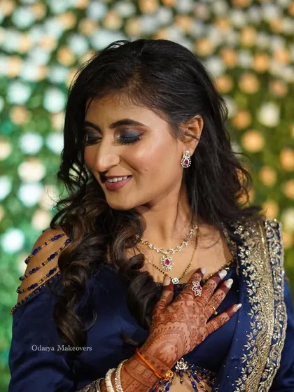 A soft, smiling pose showing off the beautiful blue eyeshadow and flawless skin. This look is perfect for a bride who wants to make a statement at her reception.